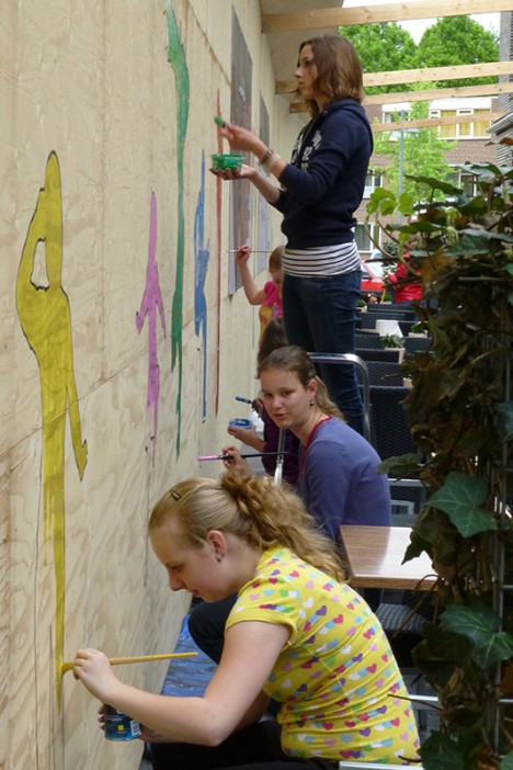 de schutting van Komma wordt beschilderd