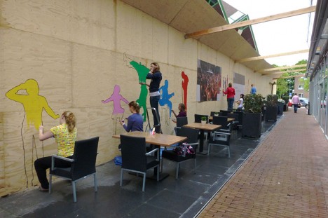 de schutting van Komma wordt beschilderd